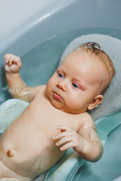 Zdjęcie pierwsze kąpiele dla niemowląt opieka nad nowonarodzonym niemowlęciem kąpanie niemowlęcia w wannie nowonarodzone niemowlę kąpa się w wodzie