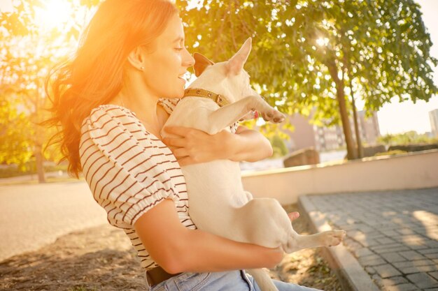 Pies rasy parson russell terrier bawi się w zielonym parku ze swoim właścicielem w okresie letnim lub na początku