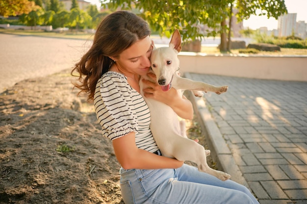 Pies rasy parson russell terrier bawi się w zielonym parku ze swoim właścicielem w okresie letnim lub na początku