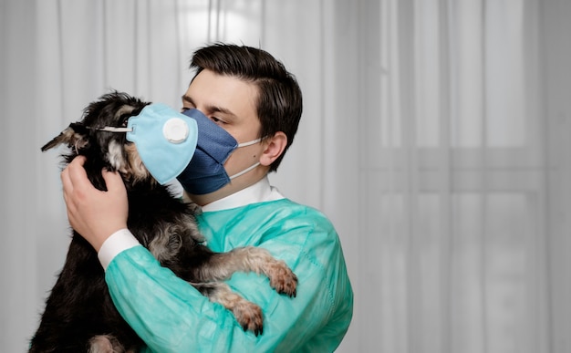 Pies w masce ochronnej, niehigieniczne warunki, lekarz trzyma w rękach psa chorego na koronawirusa,
