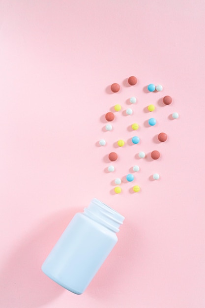 Zdjęcie pigułki i butelki na pigułki na różowym tle, różne pigułki farmaceutyczne, tabletki i kapsułki