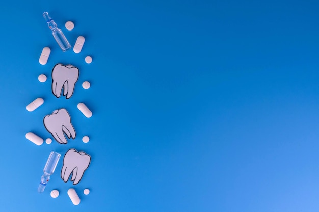 Pigułki i zęby na niebieskim tle Koncepcja bólu zęba Skopiuj miejsce
