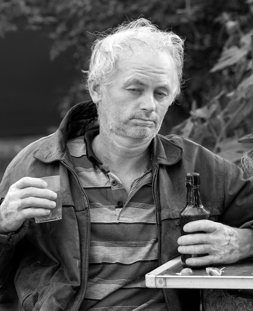 Pijany mężczyzna pijący piwo na naturalnym tle