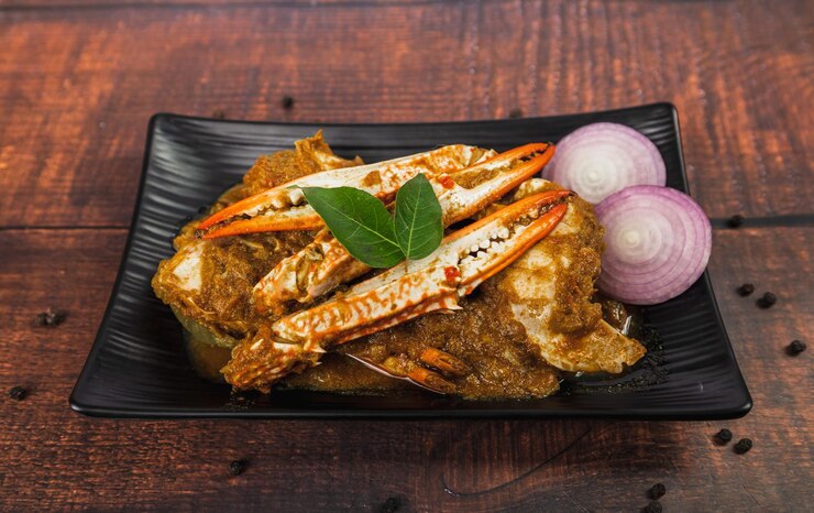 Pikantna i pyszna pieczeń krabowa na drewnianym stole Smażony krab z curry w proszku z cebulą