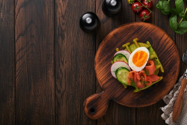 Pikantne Gofry śniadanie Zielone Gofry Dziki Czosnek Lub Szpinak Z Jajkiem łosoś Pomidorowy Na Drewnianym Talerzu Na śniadanie Na Starym Ciemnym Drewnianym Tle Lekka Kolacja Lunch Lub śniadanie Widok Z Góry Makieta