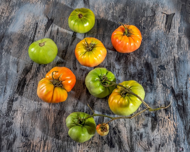 Pikantne zielone i czerwone pomidory na szarym widoku z blatu