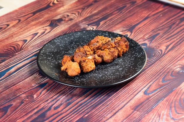 Pikantny grill z kurczaka tikka boti kabab podawany w naczyniu na białym tle na tle widoku z góry