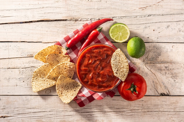 Zdjęcie pikantny sos chili w misce z frytkami nacho na drewnianym stole