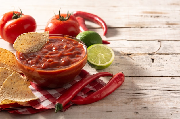 Zdjęcie pikantny sos chili w misce z frytkami nacho na drewnianym stole