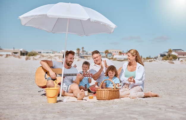 Piknik na plaży lub szczęśliwa rodzina uwielbiają muzykę gitarową podczas łączenia lub relaksu podczas letnich wakacji Dziadek tata i matka cieszą się czasem spędzonym z rodzeństwem dzieci jedzącym owoce arbuza