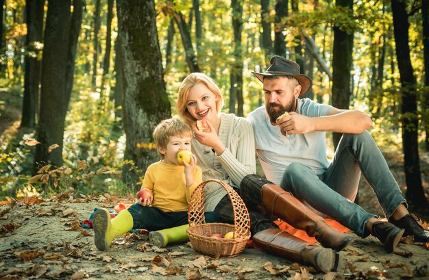 Piknik rodzinny w parku leśnym znajduje się kosz z posiłkiem i zabawkami dla dziecka koncepcja szczęśliwego