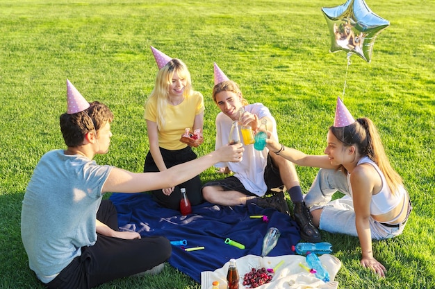 Piknik urodzinowy dla nastolatków na trawie w parku
