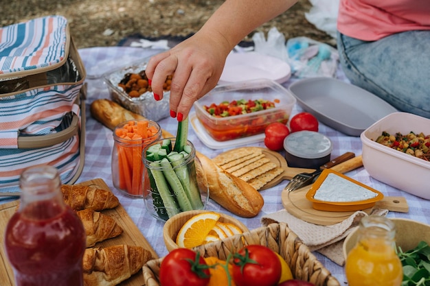 Zdjęcie piknik w lesie z warzywami, sokiem, serem i croissantami, świeżymi, ekologicznymi warzywami.
