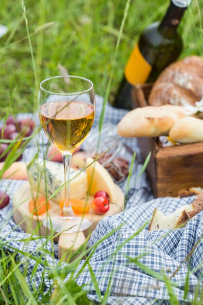 Piknik w parku na trawie: wino, sery i pieczywo