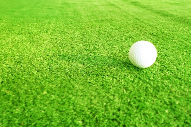 Piłeczka golfowa z bliska na zielonej trawie na rozmytym pięknym krajobrazie golfowym tleKoncepcja międzynarodowego sportu, który polega na precyzyjnych umiejętnościach dla zdrowia relaksx9