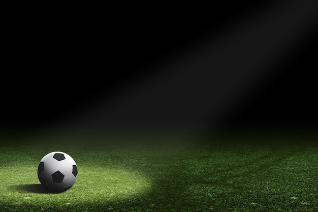 Piłka do piłki nożnej jest oświetlana pośrodku ciemnego pola