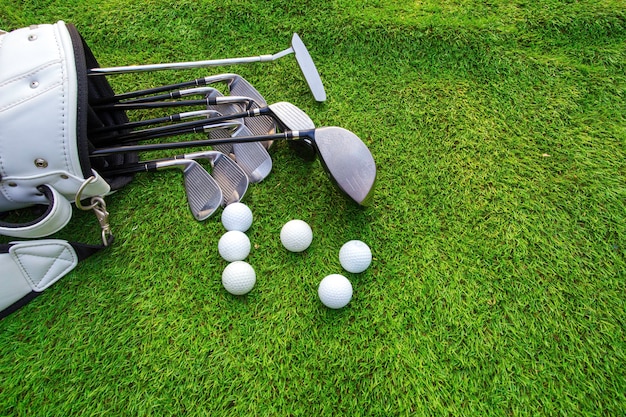 Piłka golfowa i kij golfowy w torbie na zielonej trawie