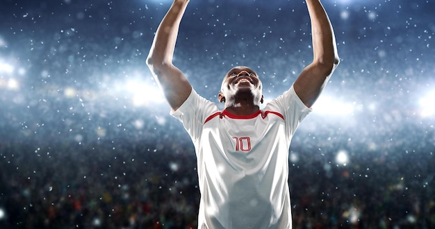 Piłkarz świętuje zwycięstwo na profesjonalnym stadionie, podczas gdy pada śnieg. Stadion i kibice są wykonane w 3D