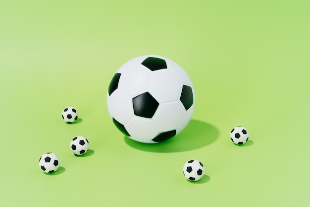Piłki nożnej o różnych rozmiarach na zielonym tle. koncepcja piłki nożnej i sportu.