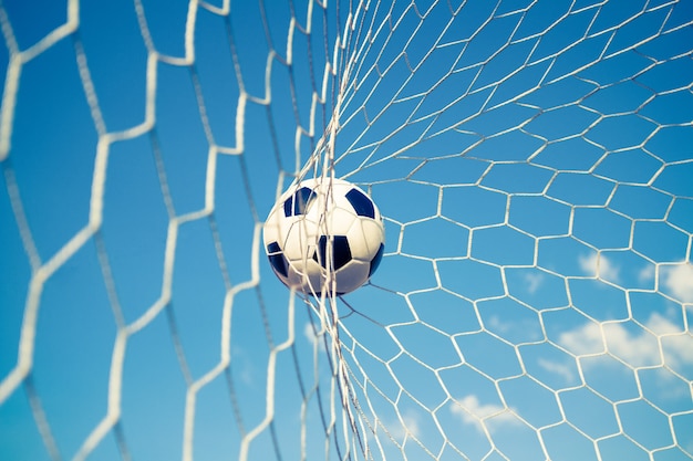 Piłki nożnej piłka w cel sieci z niebieskim niebem