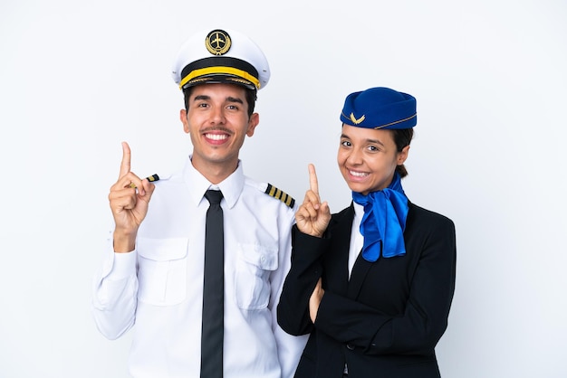 Pilot samolotu i stewardessa rasy mieszanej na białym tle pokazujący i unoszący palec na znak najlepszych