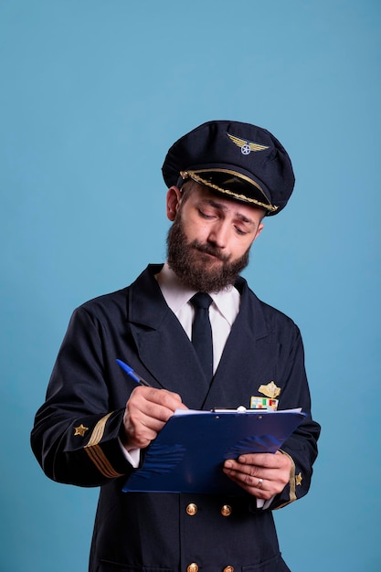 Pilot samolotu trzymający schowek, wypełniający formularz