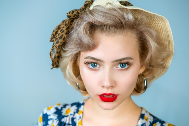 Zdjęcie pin up portret kobiety piękna retro dziewczyna w sukience z czerwonymi ustami i starą modną fryzurą portret pięknej blondynki pinup kobiety w kapeluszu