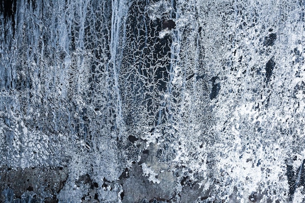 Pionowe czarne skały z lodem i śniegiem Abstrakcja lodowatej skały ze śniegiem