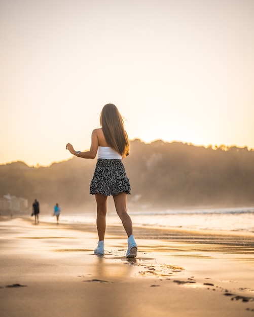 Pionowe Ujęcie Atrakcyjnej Brunetki Na Piaszczystej Plaży W Zarautz, Hiszpania