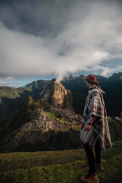 Pionowe ujęcie kaukaskiego turysty z widokiem na Machu Pichu w Peru