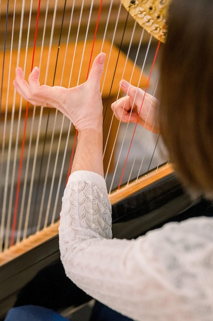 Pionowe ujęcie kobiety grającej na harfie