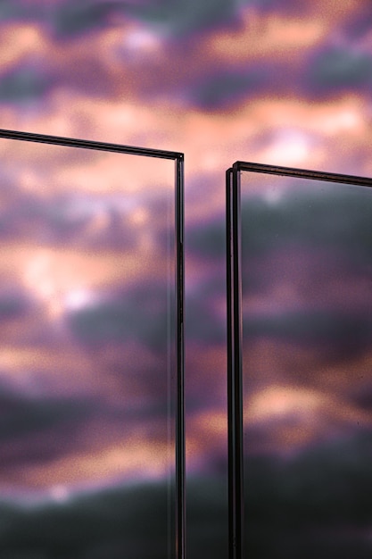 Pionowe ujęcie szklanych ogrodzeń pod pochmurnym niebem podczas pięknego fioletowego zachodu słońca wieczorem