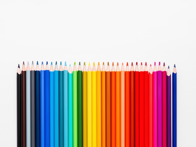 Pionowo rząd kolorowi ołówki na bielu.