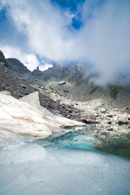 Pionowy górski krajobraz małego alpejskiego jeziora