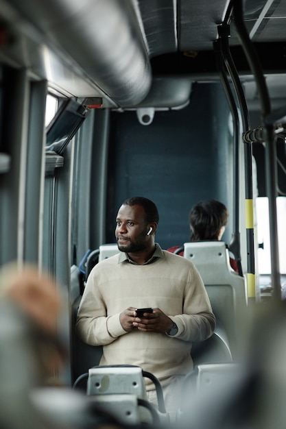 Pionowy Portret Afro-amerykańskiego Mężczyzny Patrzącego Na Okno W Autobusie Podczas Podróży Transportem Publicznym W Mieście