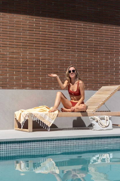 Pionowy widok makiety młodej kobiety udającej, że latem trzyma coś na dłoni w basenie