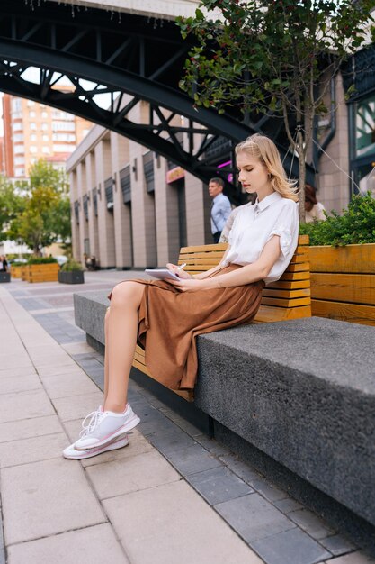 Pionowy widok z boku skoncentrowanej kreatywnej hipsterki artystki rysującej w szkicowniku, cieszącej się spędzaniem wolnego czasu na hobby Zamyślona młoda kobieta pisze notatki