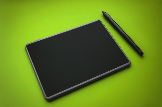 Pióro do tabletu graficznego na powierzchni urządzenia, zdjęcie w zbliżeniu. tablet graficzny z piórem dla ilustratorów i projektantów, na zielonym tle.