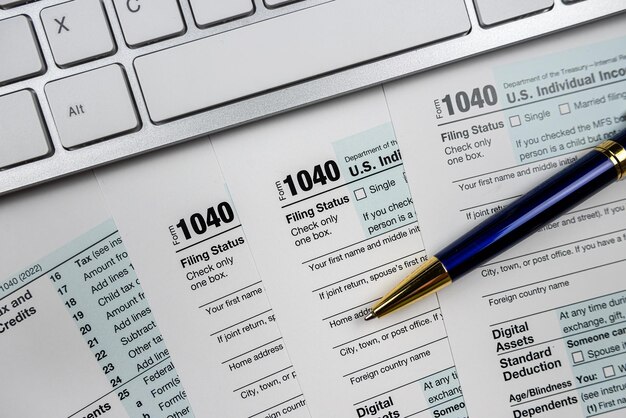Pióro z klawiaturą komputerową na biurku z podatku od finansów biznesowych