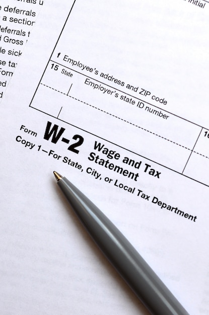 Zdjęcie pióro znajduje się na formularzu podatkowym w-2 wynagrodzenie i rozliczenie podatkowe. czas płacenia podatków