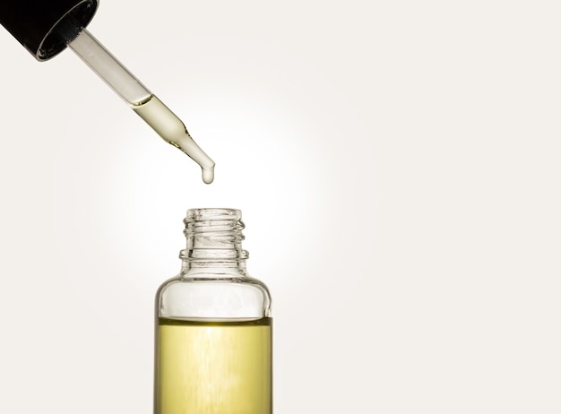 Pipeta z olejem kosmetycznym na jasnym tle butelka kosmetyków do pielęgnacji skóry, włosów i ciała