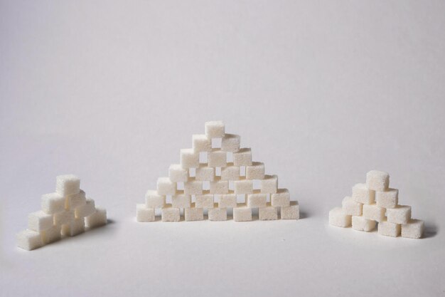 piramida kostek cukru na białym tle. zbliżenie