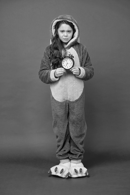 Piżama Kigurumi dla Twojej wygody Śmieszne dziecko w piżamie z królikiem Różne pory dnia i koncepcja harmonogramu dzieci Budzik rano smutny dzieciak w piżamie do snu Sprawdź czas