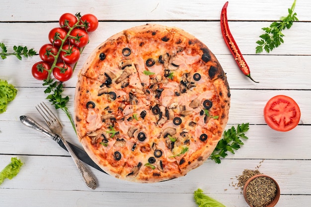 Pizza capricciosa Szynka Mozzarella Pieczarki Oliwki Widok z góry Na drewnianym tle Kopiowanie miejsca