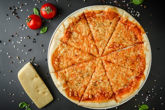 Pizza margarita i składniki na ciemnym tle