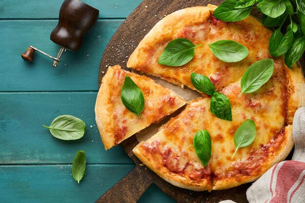 Pizza Margarita Tradycyjna neapolitańska pizza margarita i składniki do gotowania pomidory bazylia na drewnianym tle stołowym włoskie tradycyjne jedzenie widok z góry