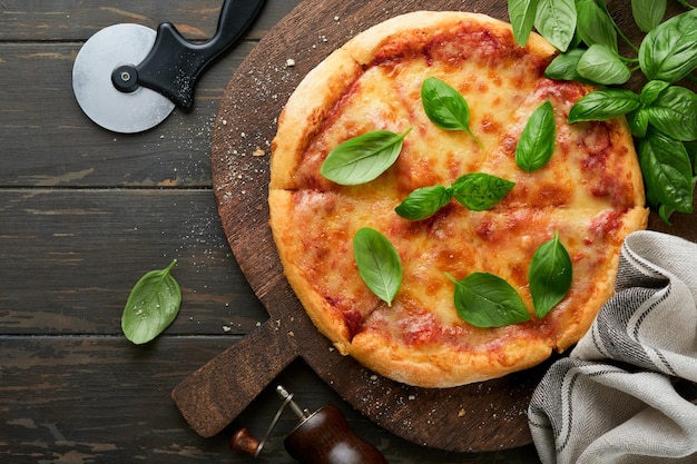 Pizza Margarita Tradycyjna neapolitańska pizza margarita i składniki do gotowania pomidory bazylia na drewnianym tle stołowym włoskie tradycyjne jedzenie widok z góry