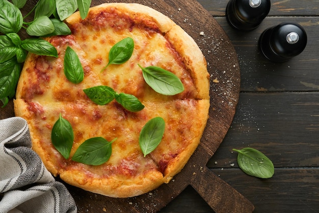 Pizza Margarita Tradycyjna neapolitańska pizza margarita i składniki do gotowania pomidory bazylia na drewnianym tle stołowym włoskie tradycyjne jedzenie widok z góry