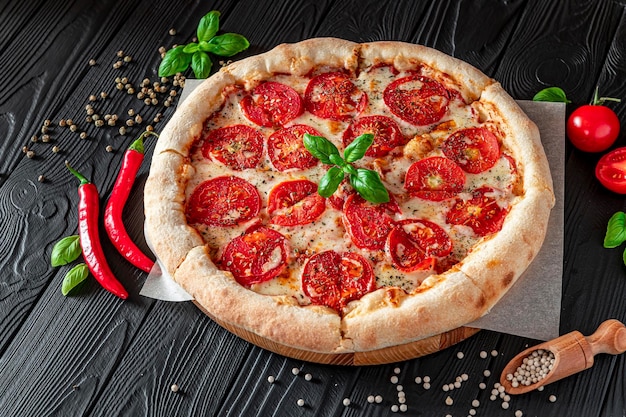 Pizza Margherita na czarnym tle widok z góry Pizza Margarita z pomidorami, bazylią i serem Mozzarella