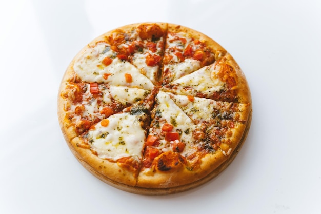 Pizza margherita na okrągłej drewnianej desce do krojenia na białym czystym stole